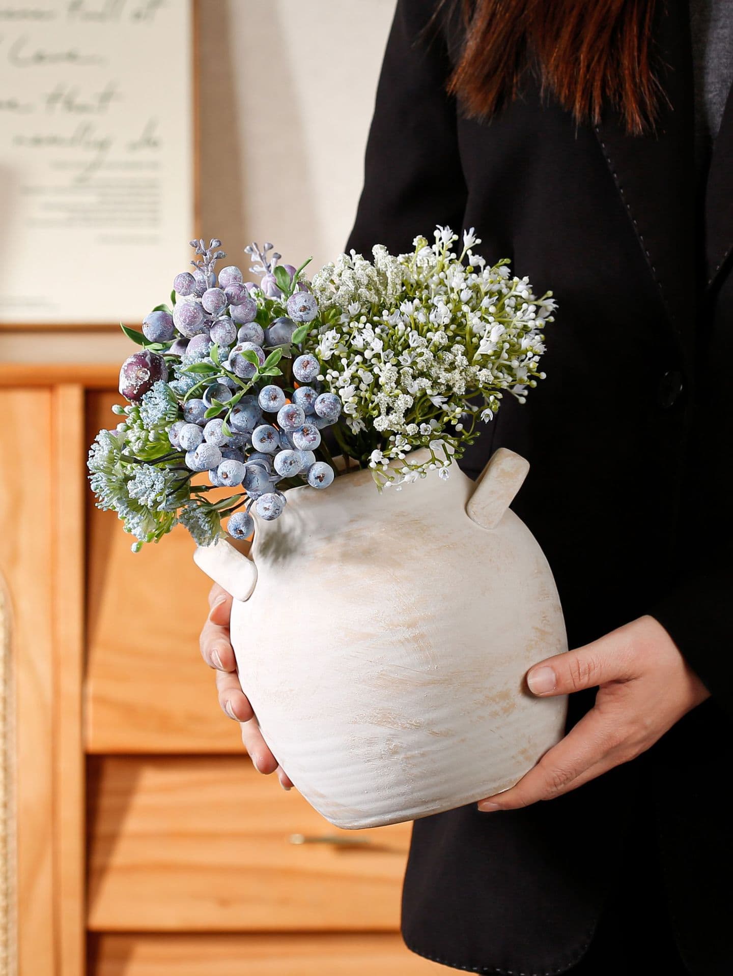 Retro handmade ceramic vase held with blue flowers