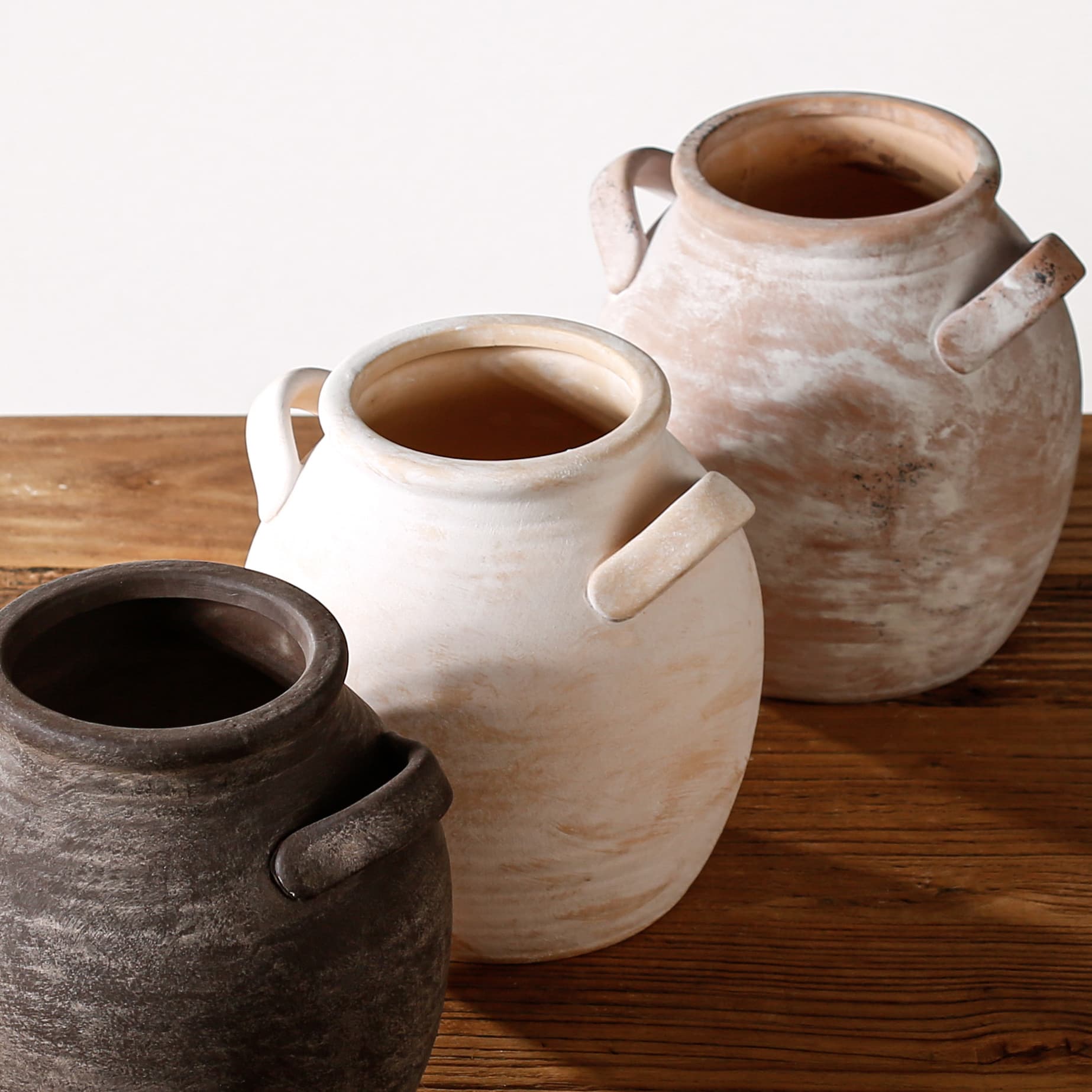 Three retro handmade ceramic vases showing aged glaze finishes