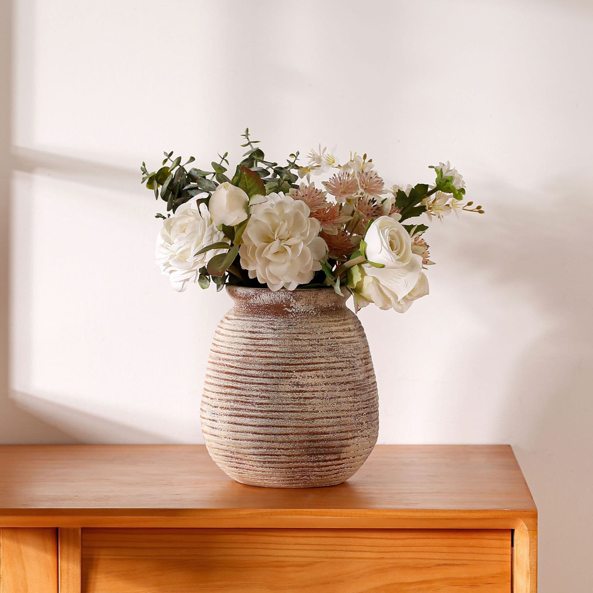 Antique taupe horizontal ribbed ceramic vase styled on a shelf