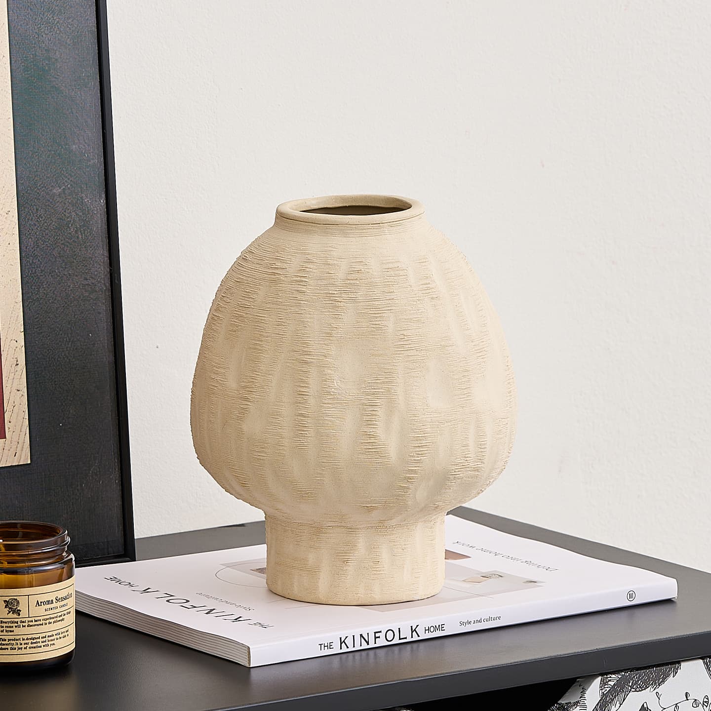 Large ivory brushed ceramic vase on stacked books