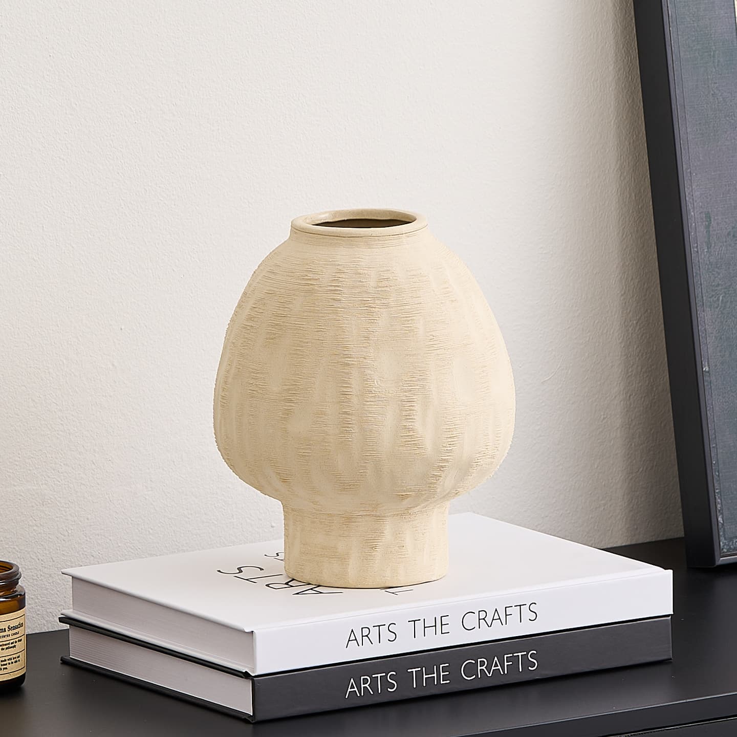 Minimal ivory ceramic vase displayed on books